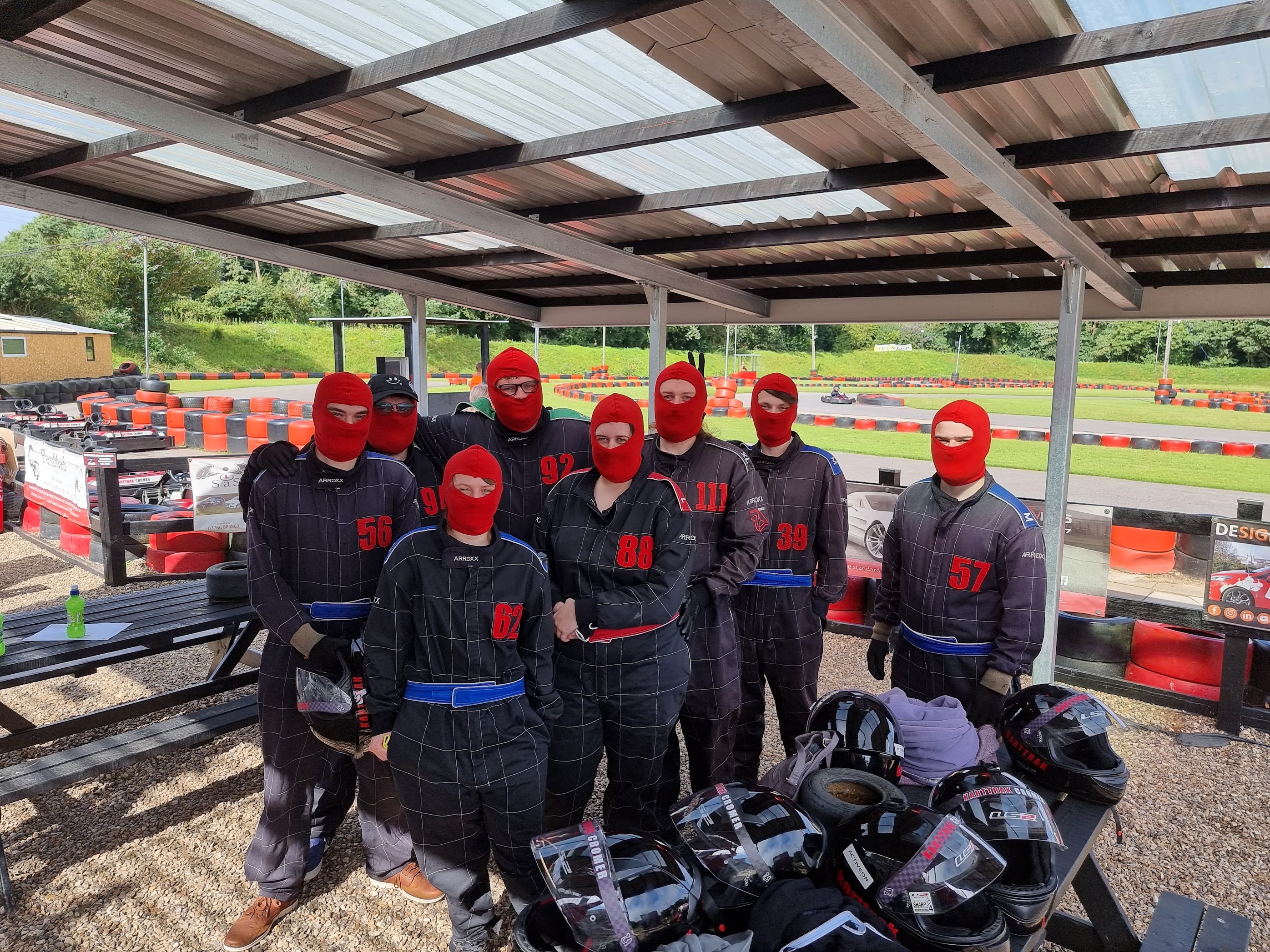A photo of us all as a group dressed up in race suits before we go out racing go karts